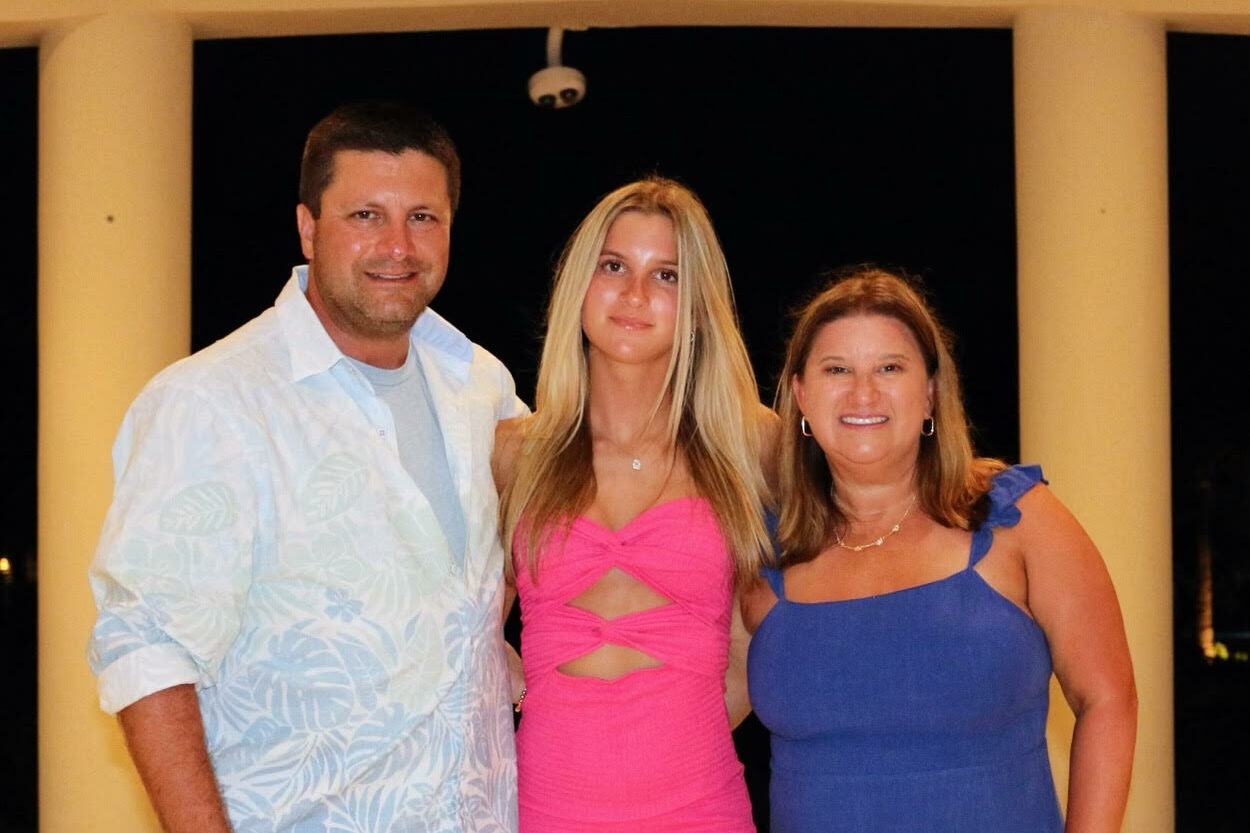 picture of Ross, his wife, and his daughter smiling for a photo