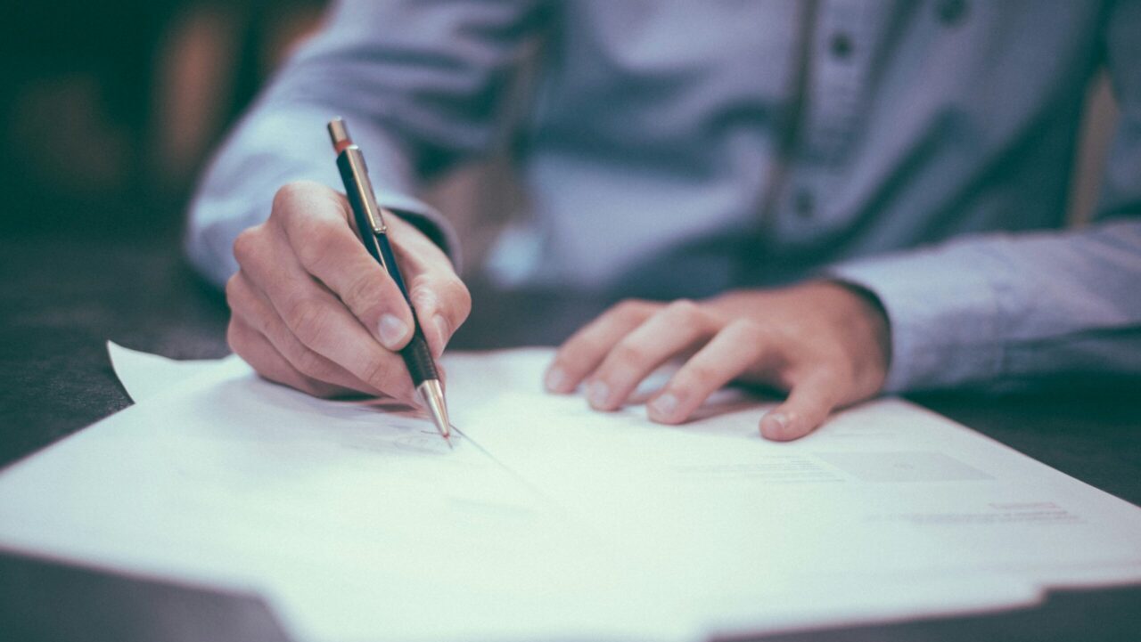 man writing on paper